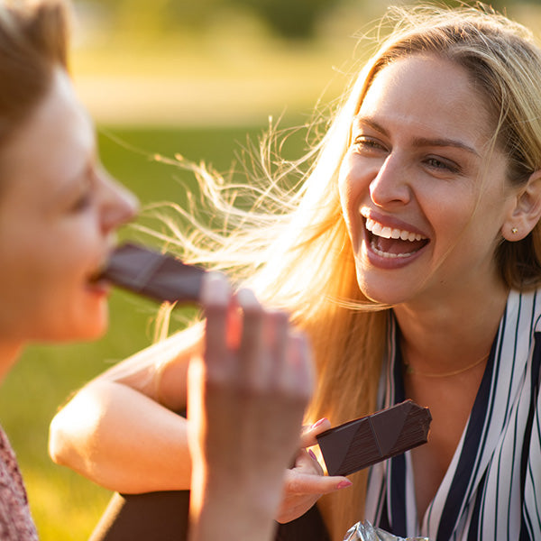 women eating mood-boosting chocolate